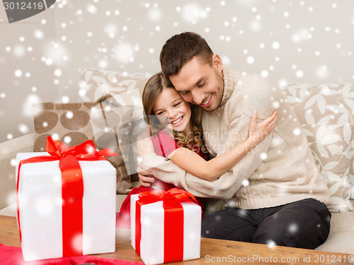 Image of smiling father and girl with gift boxes hugging