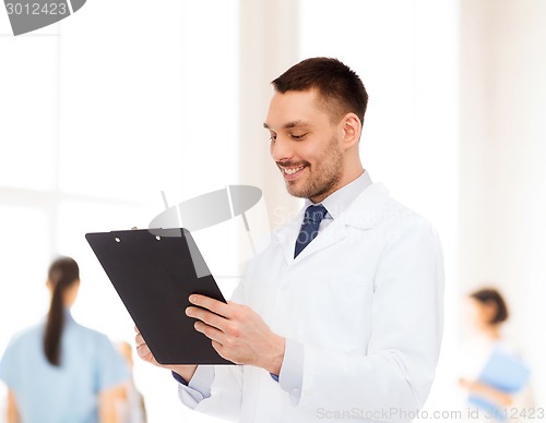 Image of smiling male doctor with clipboard