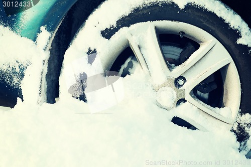 Image of closeup of car wheel stuck in snow