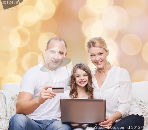 Image of happy family with laptop computer and credit card