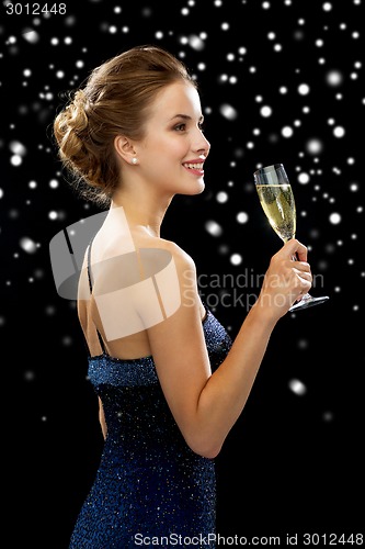 Image of smiling woman holding glass of sparkling wine