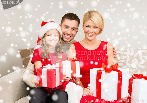 Image of smiling family holding many gift boxes