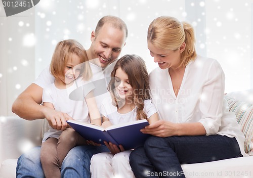 Image of happy family with book at home