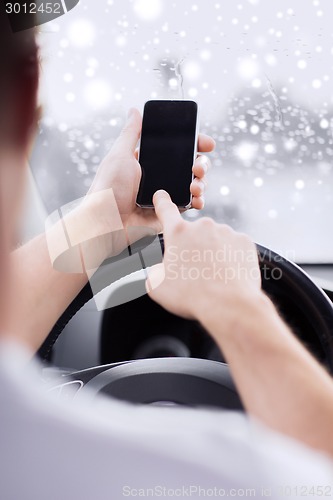 Image of close up of man using smartphone while driving car