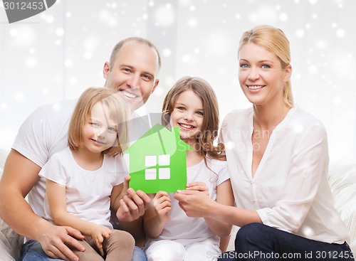 Image of happy family with two kids and paper house at home