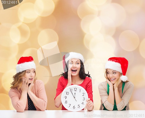 Image of smiling women in santa helper hat with clock