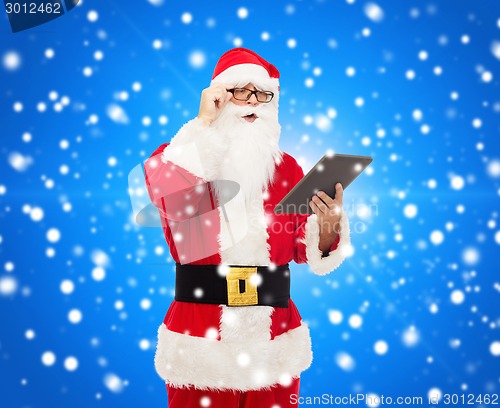 Image of man in costume of santa claus with tablet pc