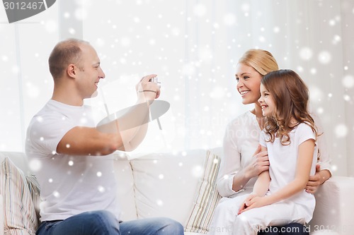 Image of happy family with camera taking picture at home