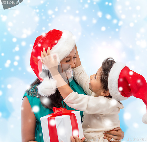 Image of happy mother and child girl with gift box