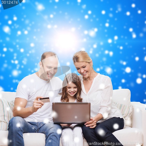Image of happy family with laptop computer and credit card