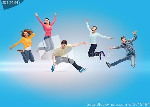 Image of group of smiling teenagers jumping in air