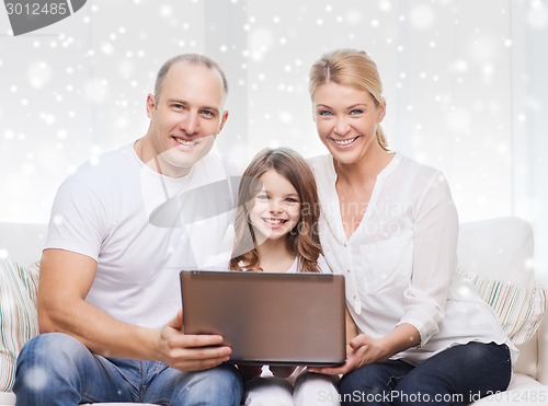 Image of smiling family with laptop at home