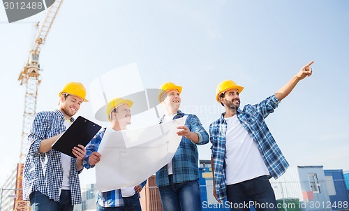 Image of group of builders with tablet pc and blueprint