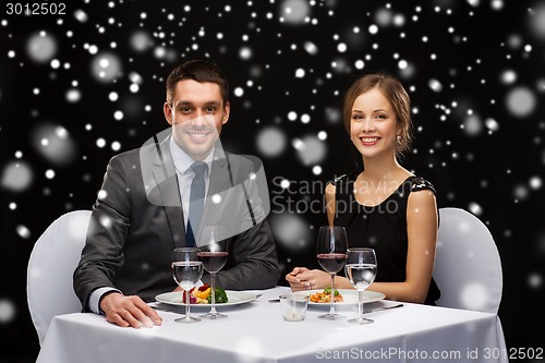 Image of smiling couple eating main course at restaurant