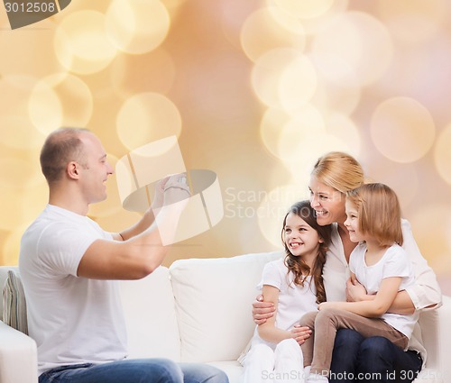 Image of happy family with camera at home