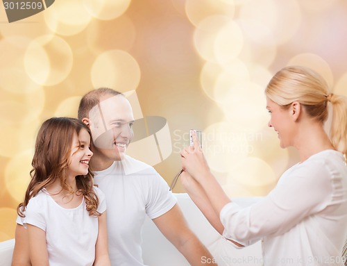 Image of happy family with camera at home