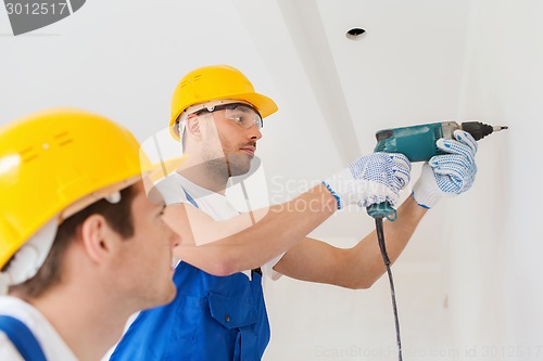 Image of group of builders with drill indoors