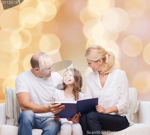 Image of happy family with book at home