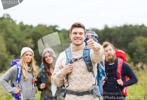 Image of group of smiling friends with backpacks hiking