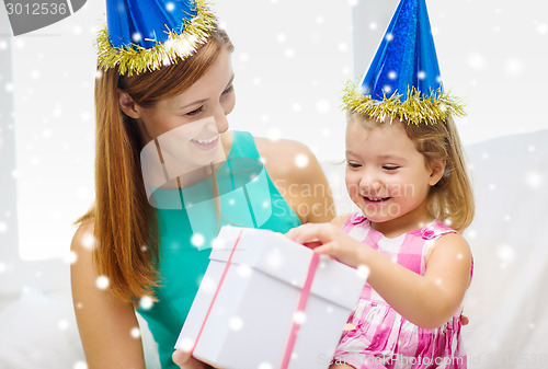 Image of mother and daughter in party hats with gift box