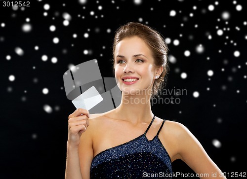 Image of smiling woman in evening dress holding credit card