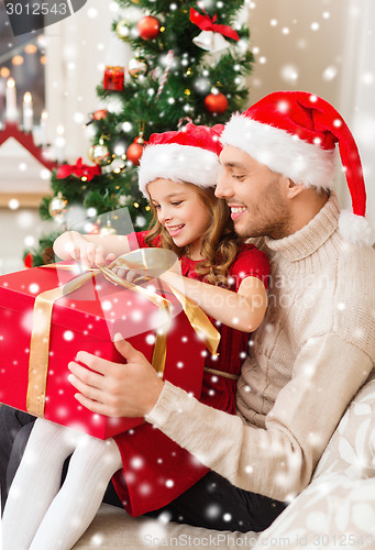 Image of smiling father and daughter holding gift box