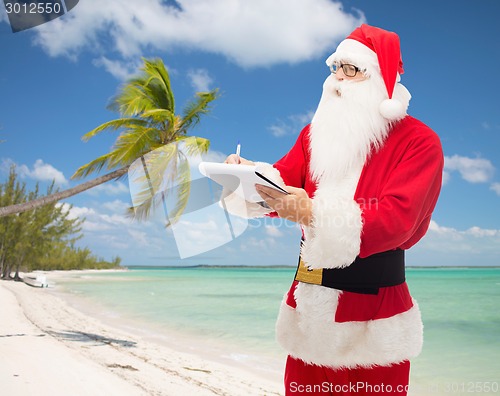 Image of man in costume of santa claus with notepad