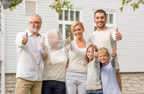 Image of happy family in front of house outdoors