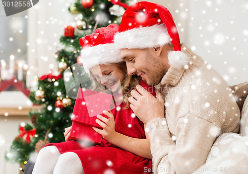 Image of smiling father and daughter holding gift box
