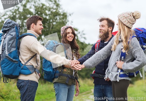 Image of group of smiling friends with backpacks hiking