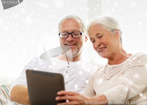 Image of happy senior couple with tablet pc at home