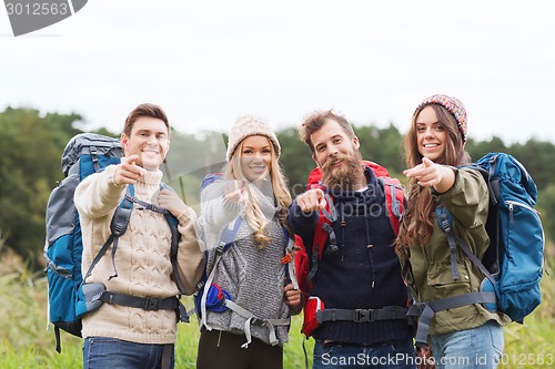 Image of smiling hikers with backpacks pointing finger