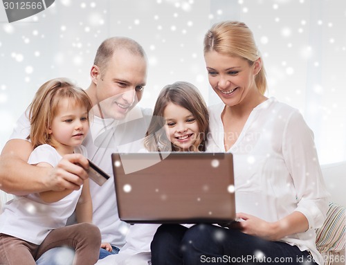 Image of happy family with laptop computer and credit card