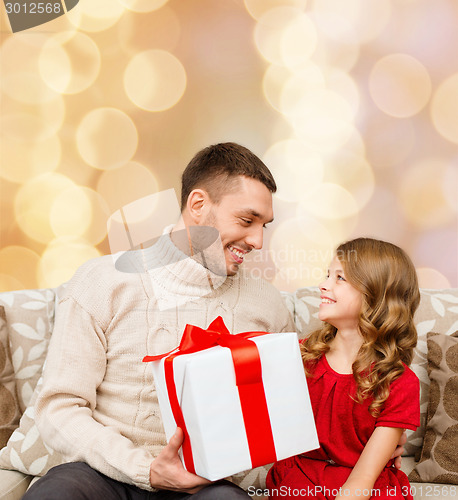 Image of smiling father and daughter with gift box