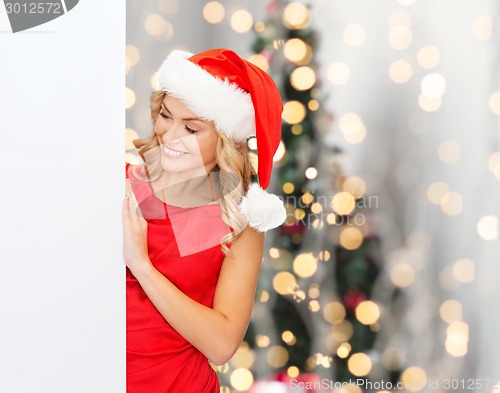 Image of smiling young woman in santa hat with white board