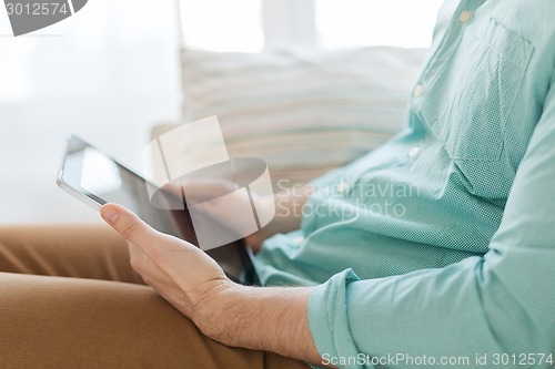 Image of close up of man with tablet pc computer at home