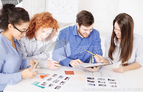 Image of team with color samples and blueprint at office