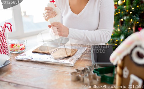 Image of close up of woman making gingerbread houses