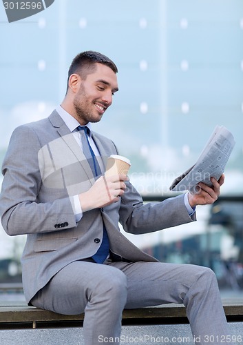 Image of young businessman with coffee and newspaper
