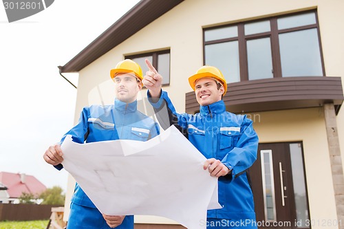 Image of group of builders with blueprint pointing finger