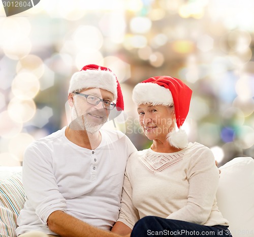 Image of happy senior couple in santa helper hats