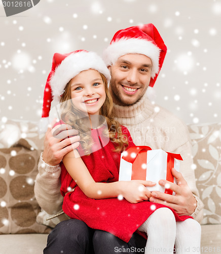 Image of smiling father and daughter holding gift box