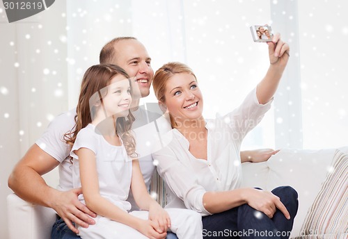 Image of happy family with camera taking picture at home