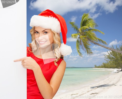 Image of smiling young woman in santa hat with white board