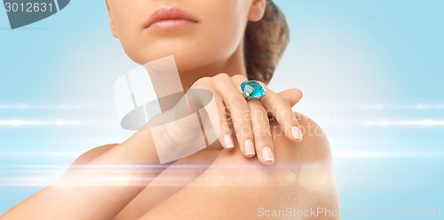 Image of closeup of woman hand with big blue cocktail ring