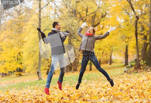 Image of smiling couple having fun in autumn park