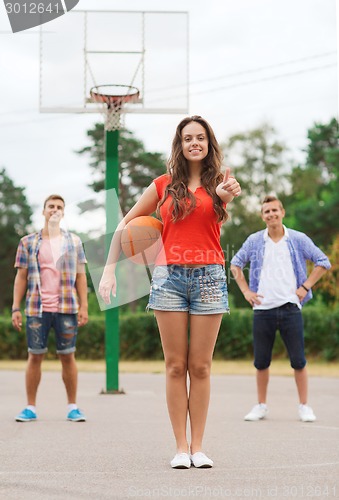 Image of group of smiling teenagers playing basketball