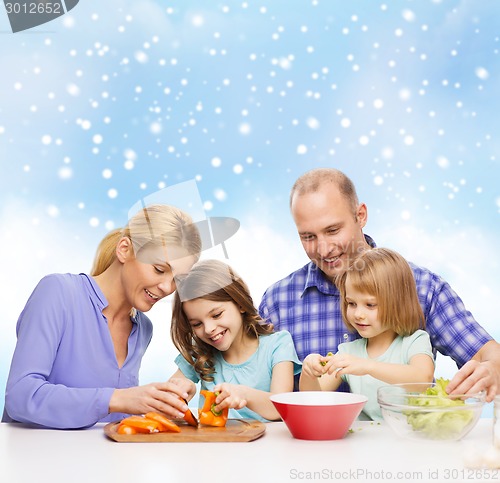 Image of happy family with two kids making dinner at home
