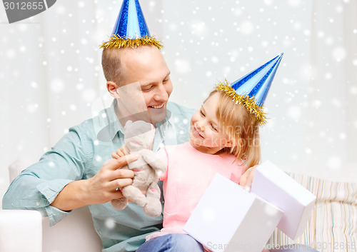 Image of father and daughter in party caps with gift box
