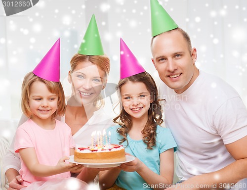 Image of happy family with two kids in party hats at home